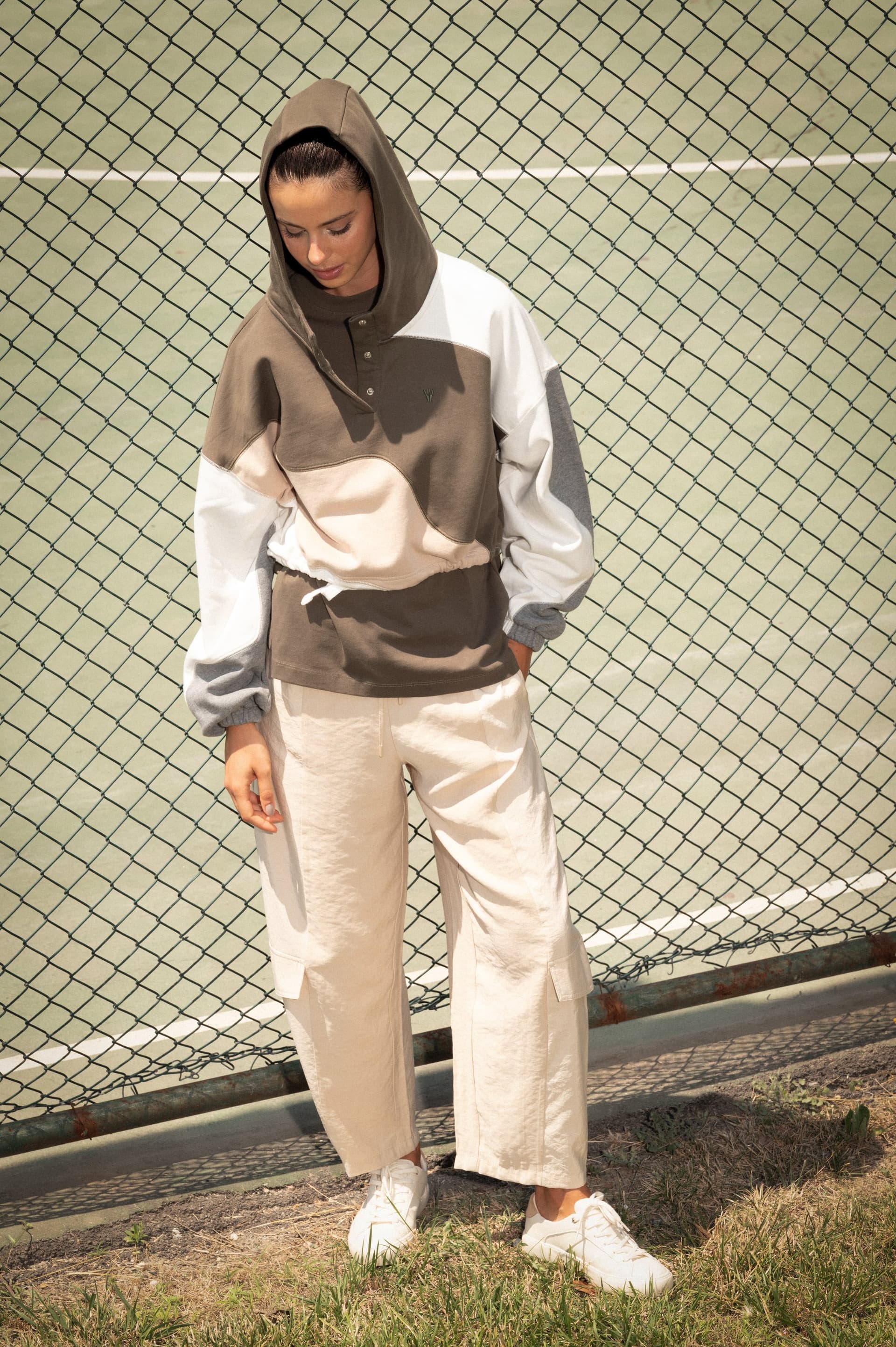 Kapüşonu başında, haki renk bloklu NOWIHT Sonia hoodie giyen model