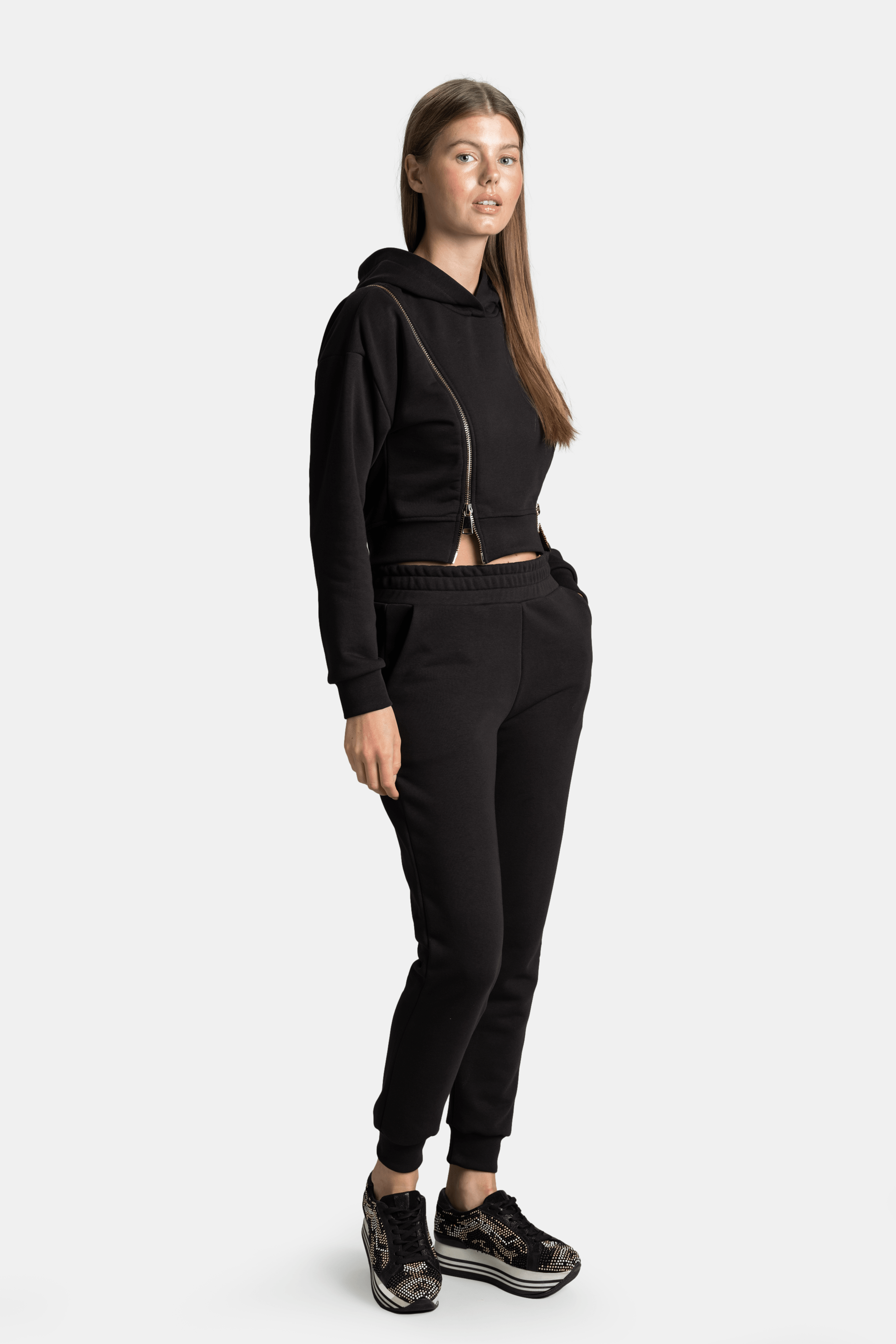 Side profile of the Amina - Zip Detail Tracksuit Set in black, capturing the modern silhouette