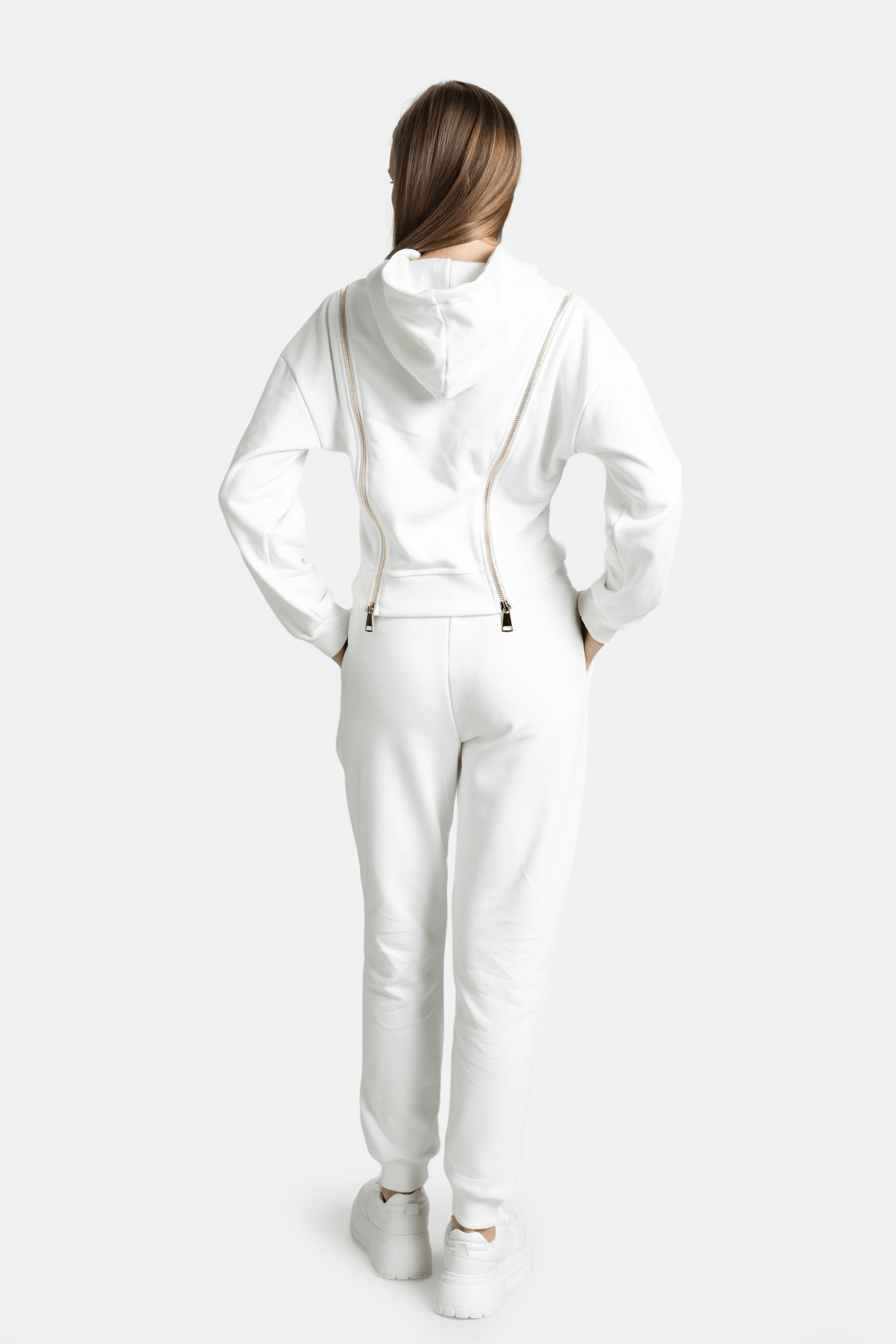 Back view of the Amina tracksuit set in ecru, highlighting the unique zip details on the hoodie and the comfortable elastic waistband of the joggers.