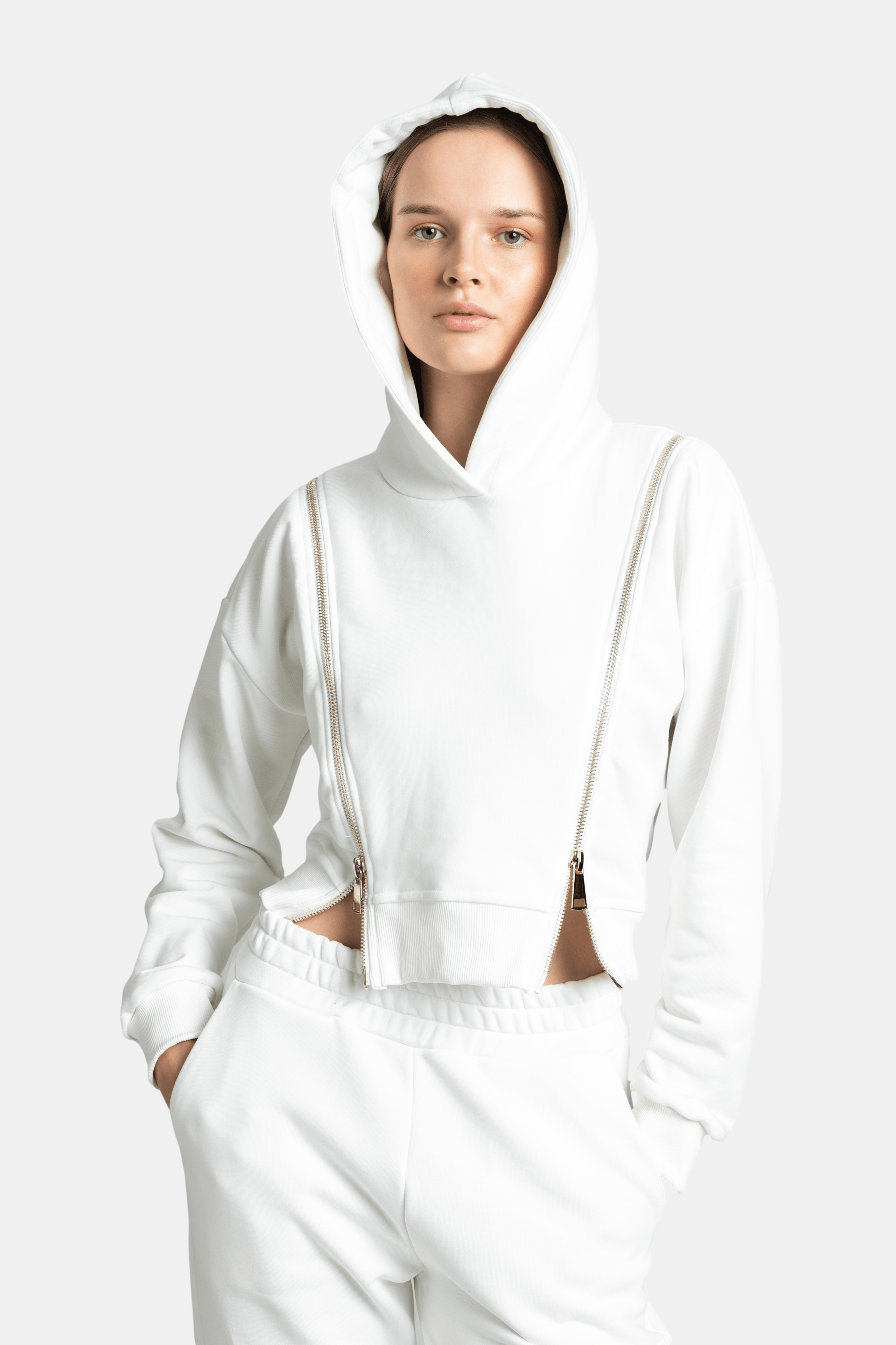 Close-up front view of the Amina hoodie in ecru with hood up, showing the intricate zip details and the soft fabric texture.