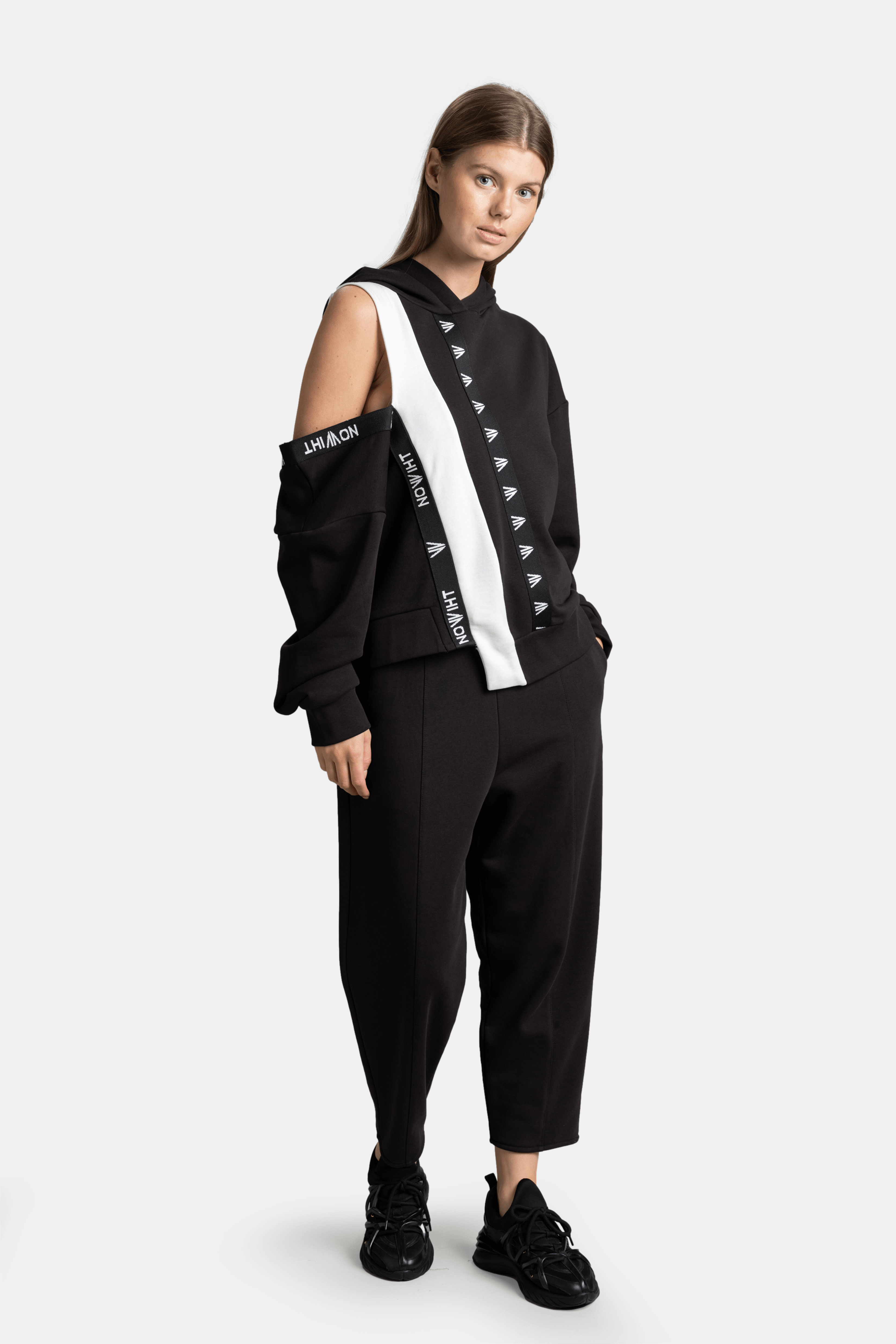 Mira - Cut Out Sleeve Tracksuit Set in Black, front view with model showcasing the unique cut-out sleeve design and Nowiht branding on a relaxed fit.