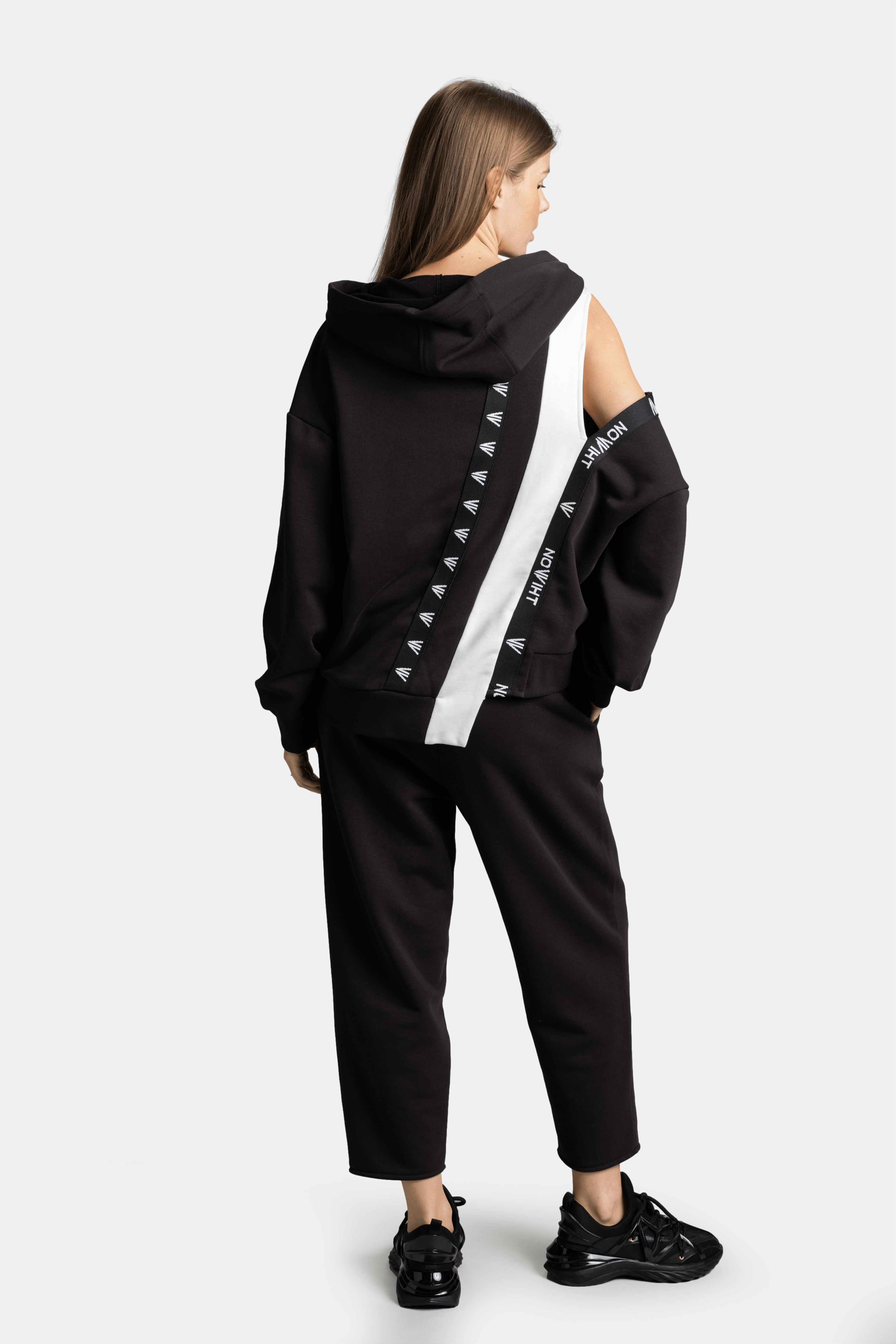 Mira - Cut Out Sleeve Tracksuit Set in Black, back view showing the distinctive white stripe with Nowiht logo detailing across the shoulder.