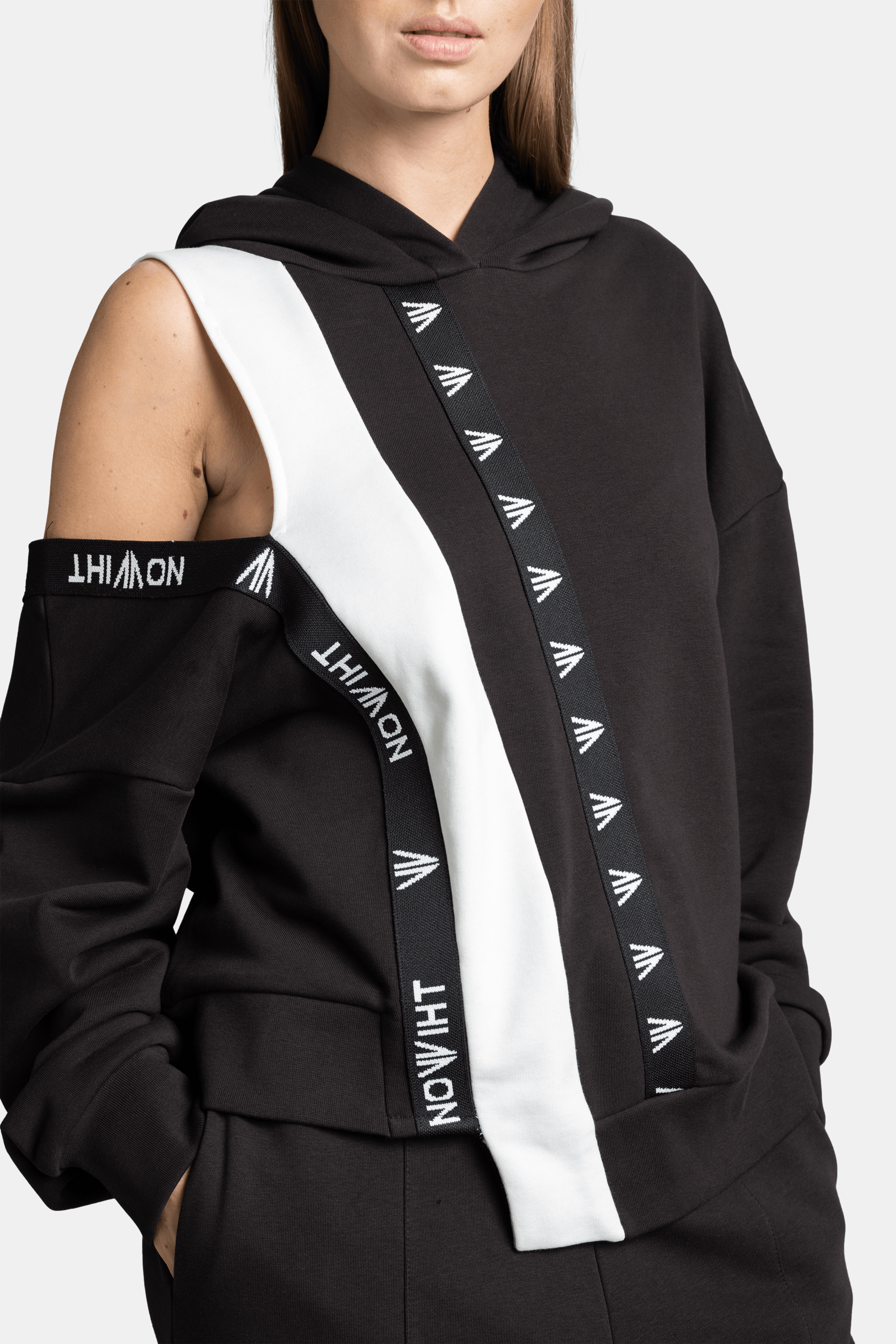 Mira - Cut Out Sleeve Tracksuit Set in Black, close-up of cut-out sleeve with Nowiht branding on the stripe for a modern look.