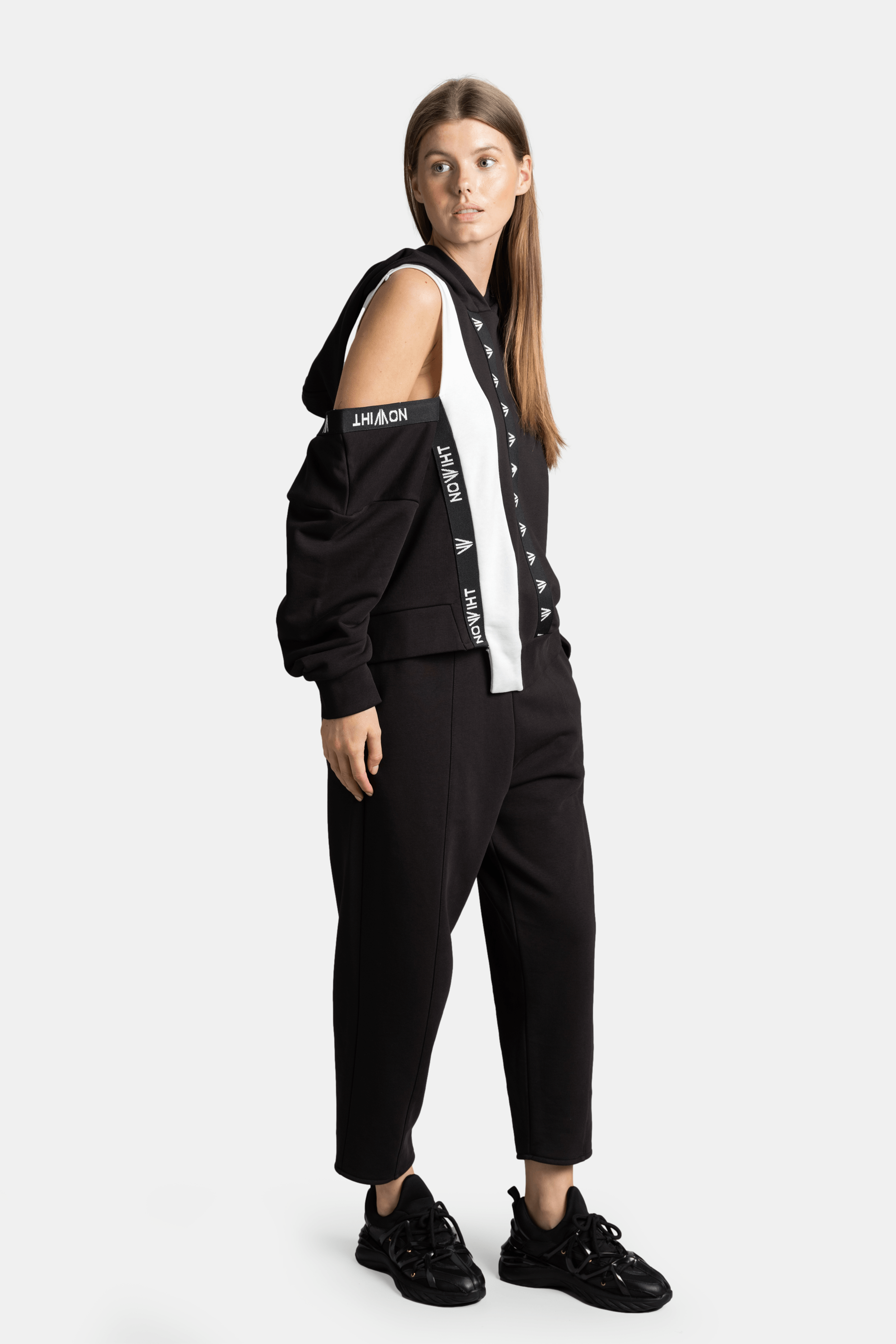 Mira - Cut Out Sleeve Tracksuit Set in Black, side angle showcasing the asymmetric white stripe and comfortable fit.