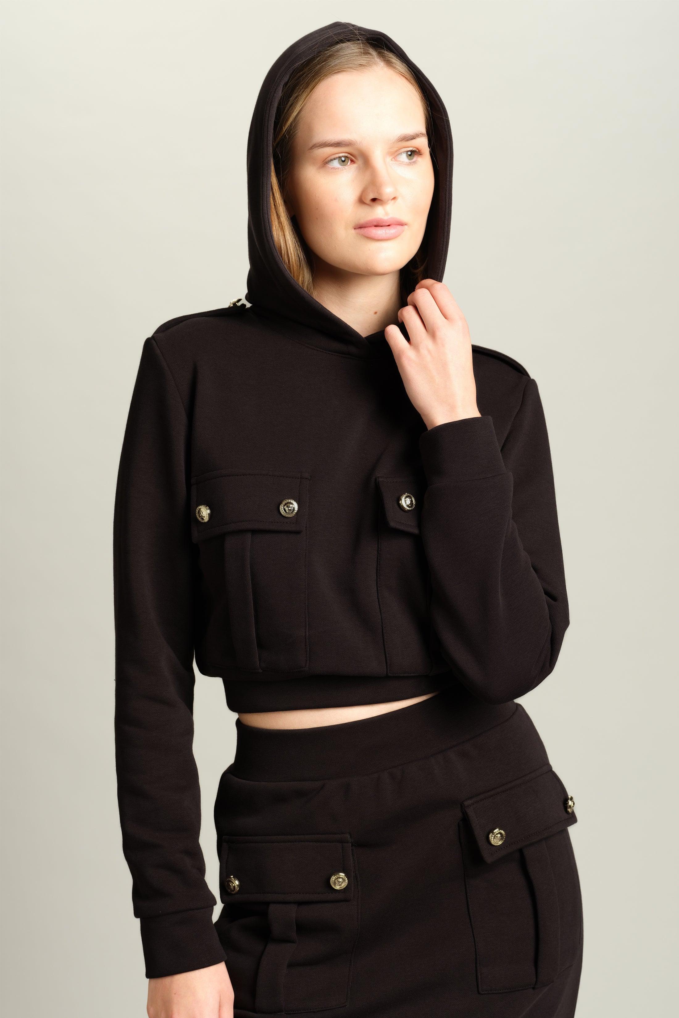 Capri - Pocket Detail Skirt Set in Black, front view with model holding the hood, emphasizing the cozy and stylish look of this versatile skirt set.