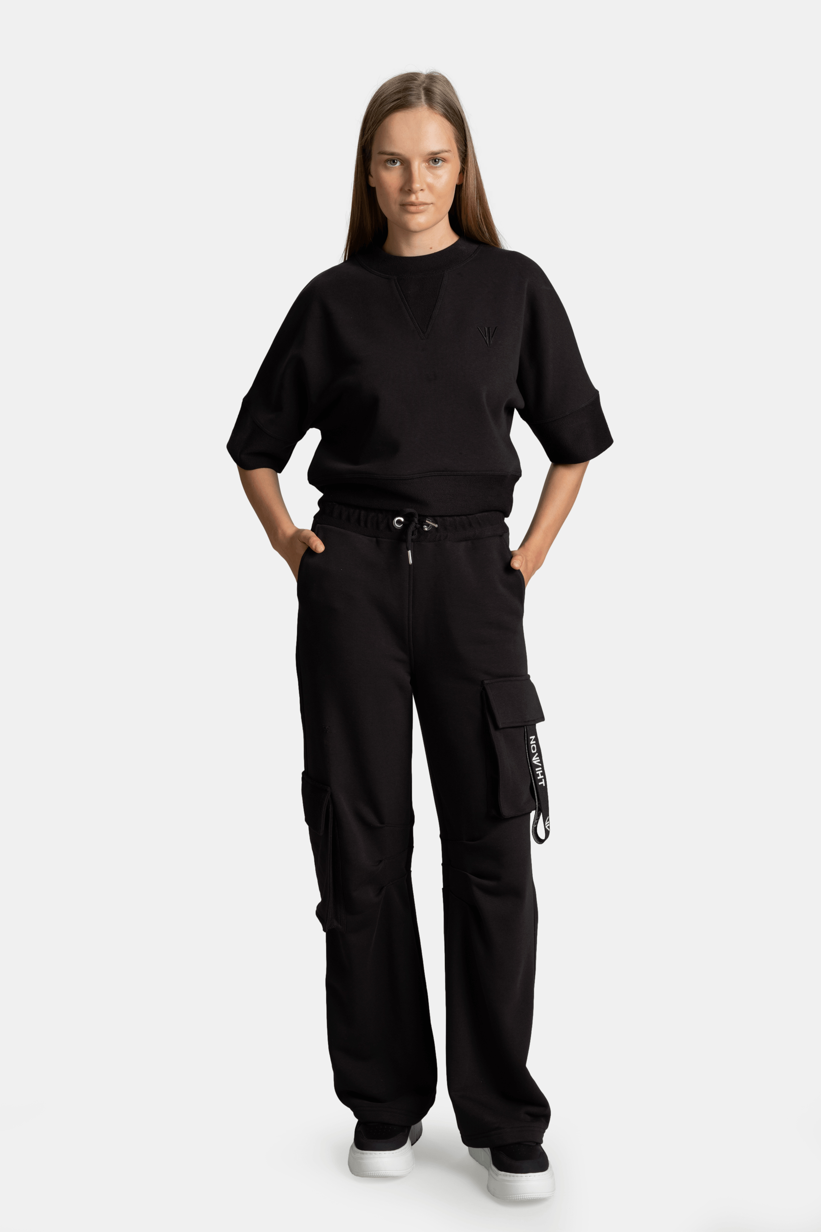 Meira - Cargo Jogger Tracksuit Set in Black, front view showcasing the model in a relaxed, stylish pose, highlighting the cargo jogger and contemporary design of the tracksuit set.