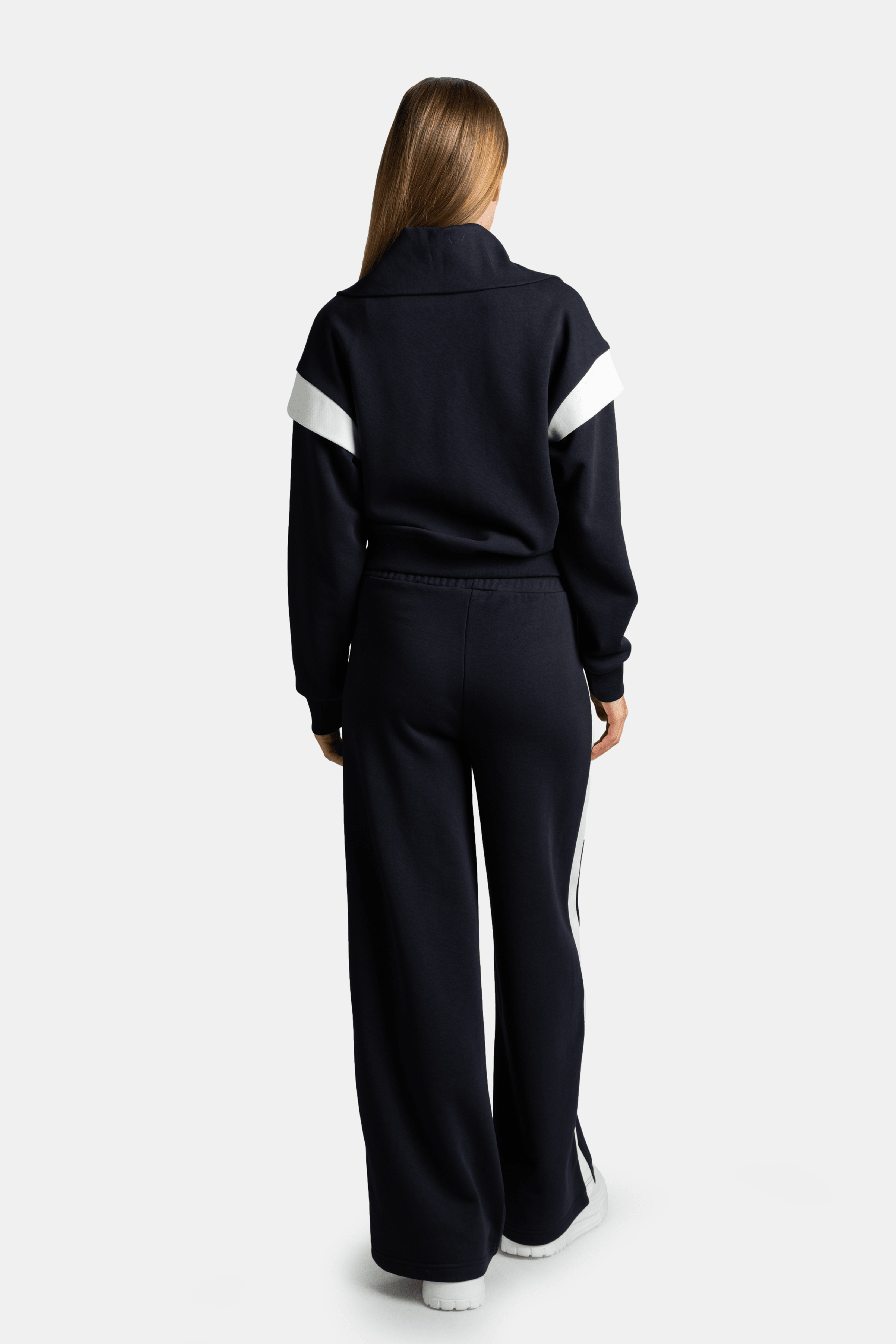 Back view of model showing Ciara zip sweatshirt tracksuit set in gray with white shoulder stripe detail