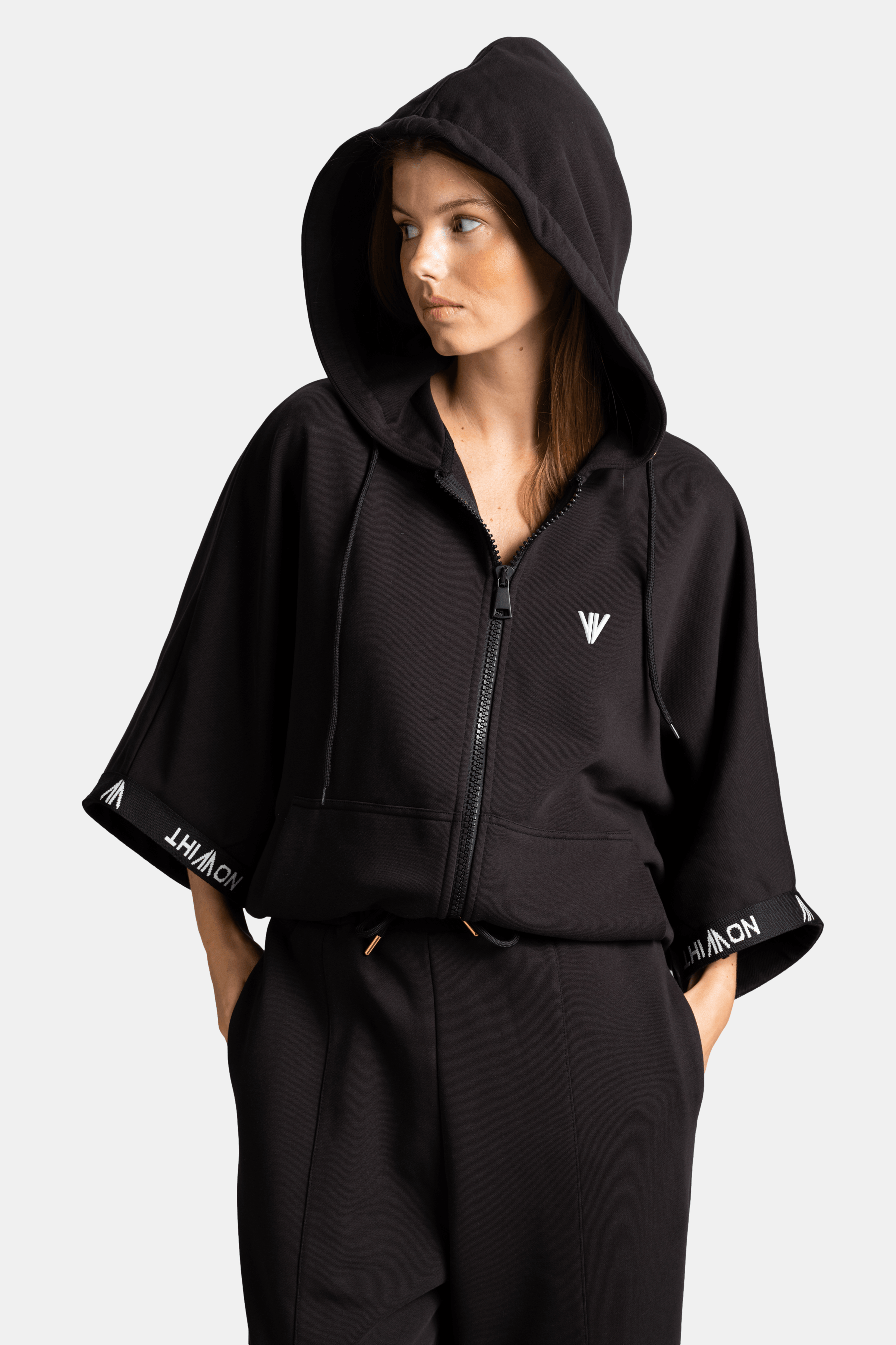 Close-up view of black parachute sleeve tracksuit set hood and sleeve details