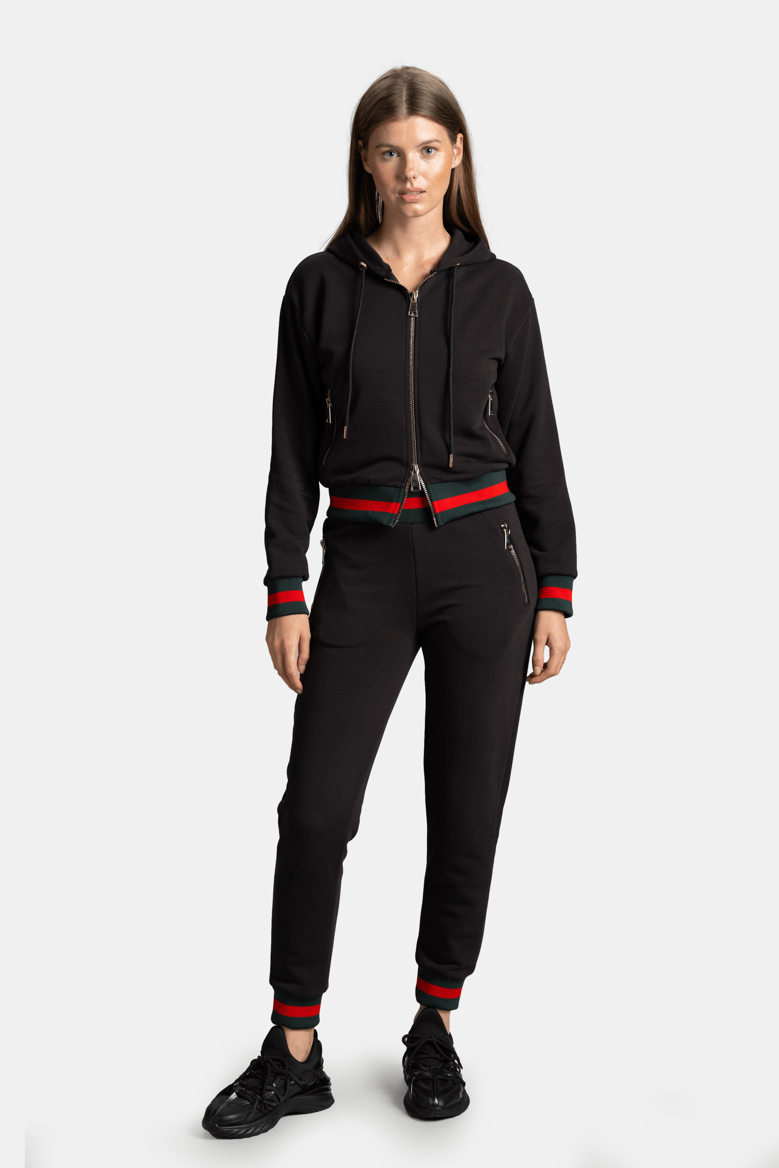 Front view of model wearing black Destiny Striped Zip Hoodie Tracksuit Set with red and green stripe details