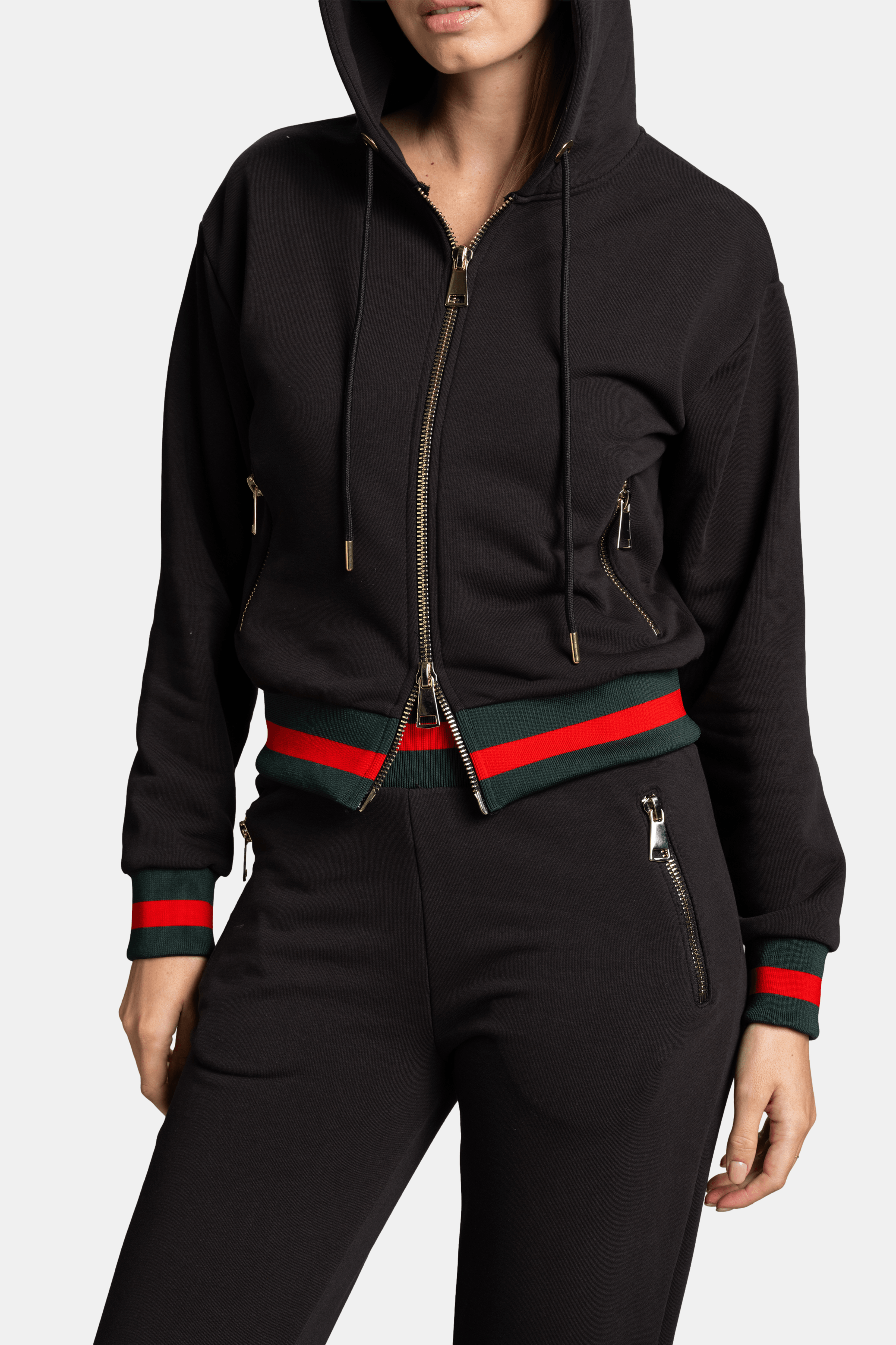 Detailed view of model holding hood of black Destiny Striped Zip Hoodie Tracksuit Set focusing on red and green stripe