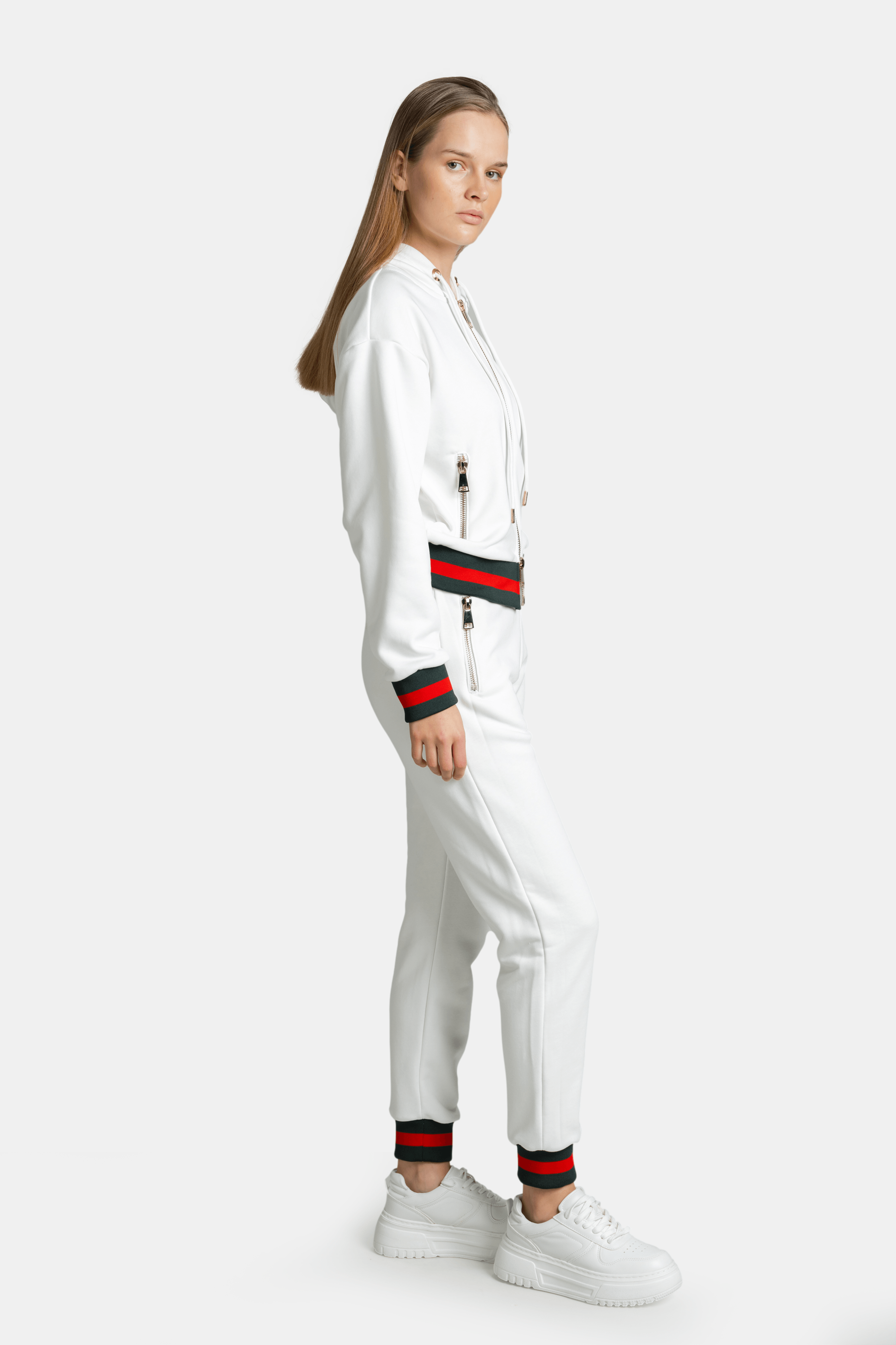 Side profile of model in white Destiny striped zip hoodie tracksuit set highlighting side zipper details