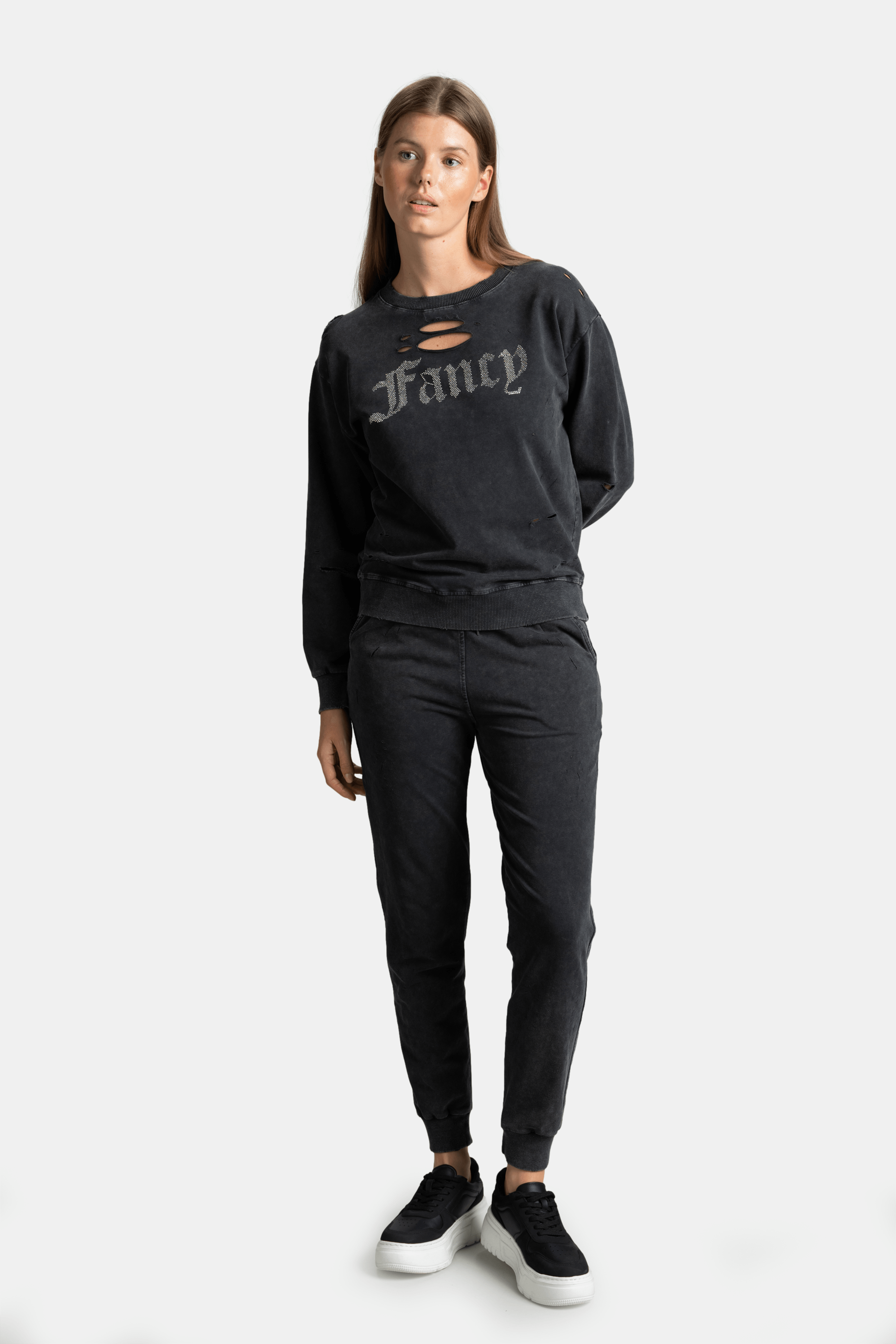 Black sweatshirt and joggers set with distressed finish and 'Fancy' gothic font, modern loungewear for women seeking a bold fashion statement.