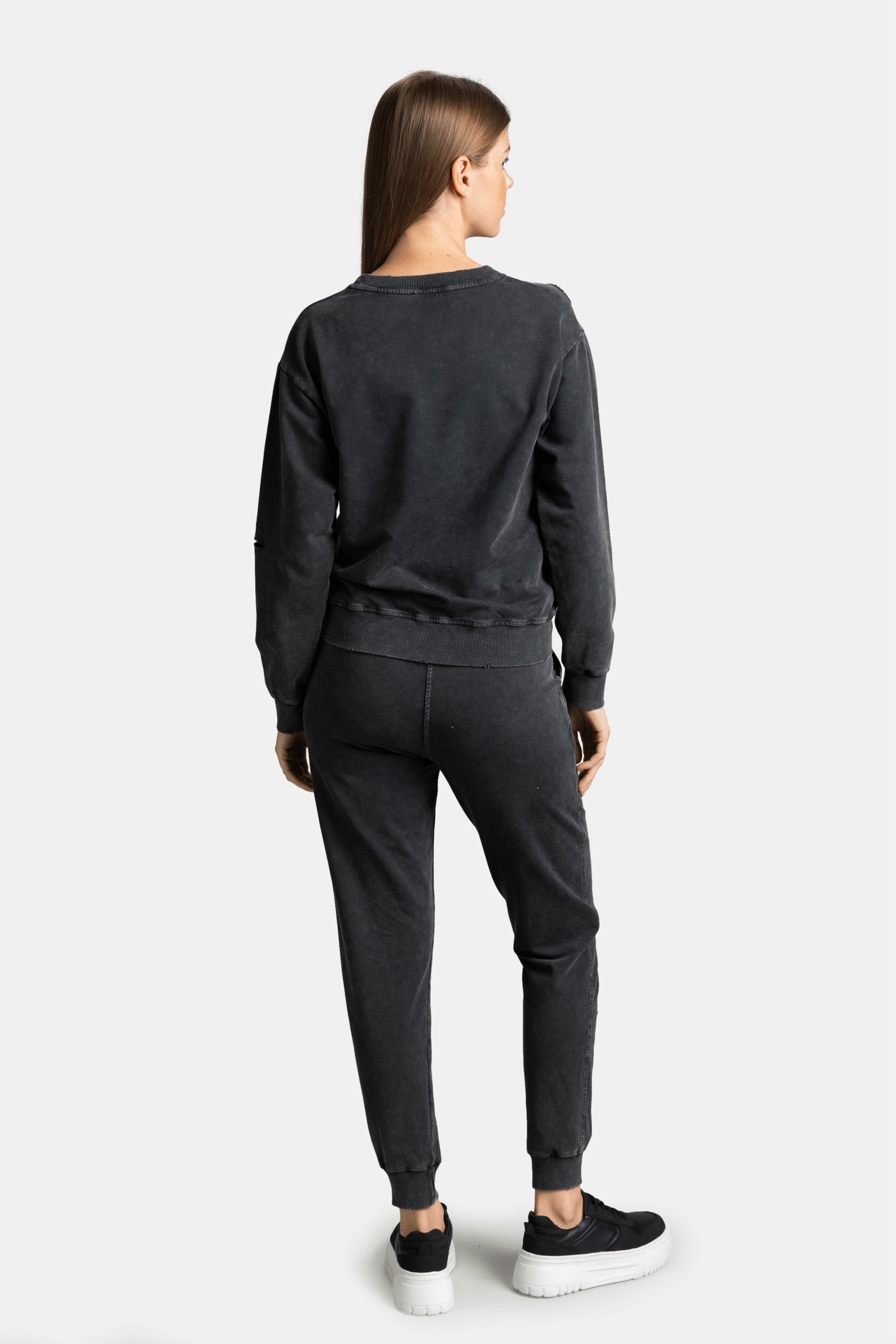 Back view of black distressed sweatshirt and joggers set with 'Fancy' text detail, perfect for relaxed and chic loungewear style, cozy and stylish fit.