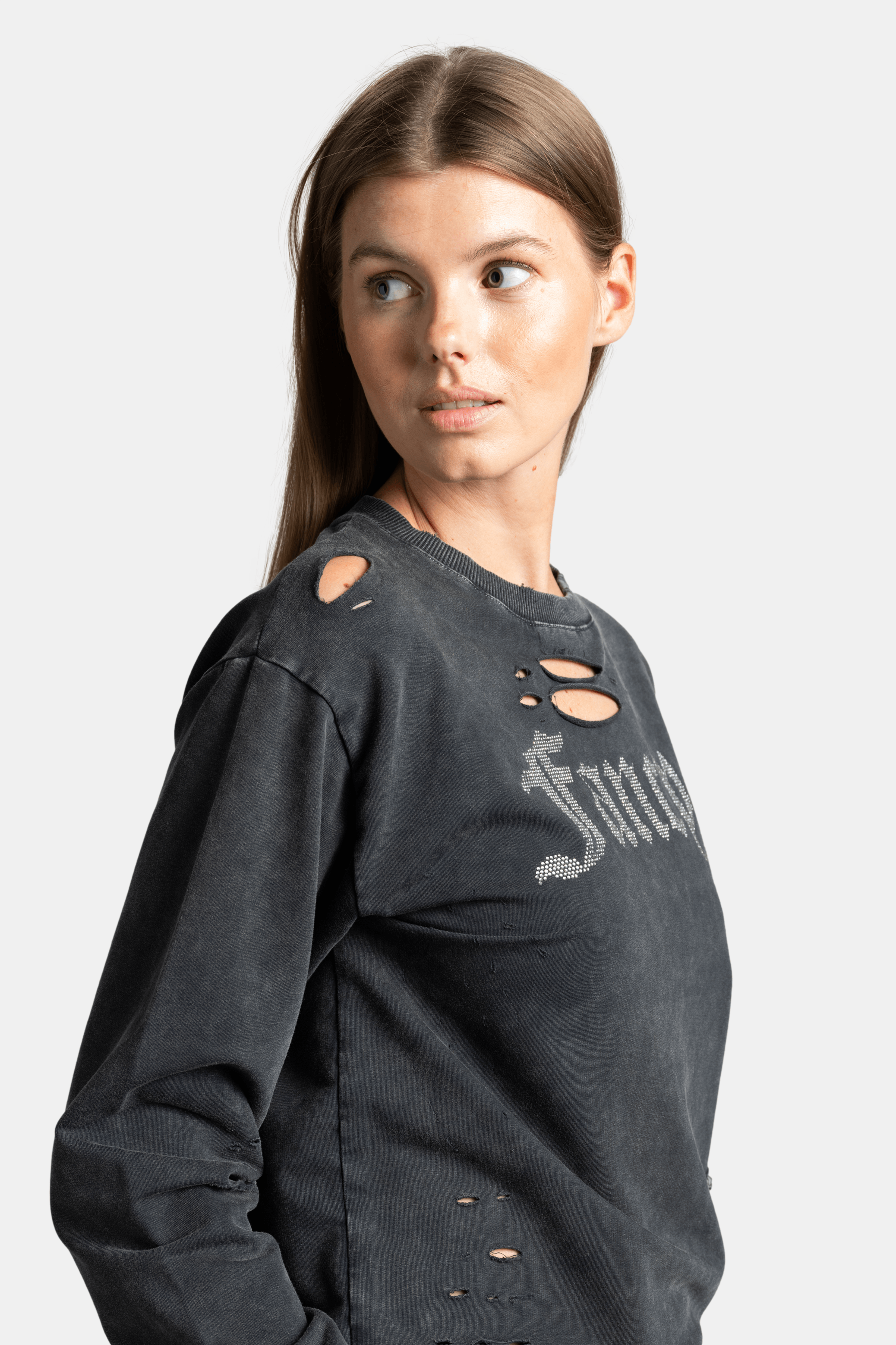 Close-up of black sweatshirt with 'Fancy' text and distressed detailing, trendy casual style, ideal for edgy and relaxed looks.