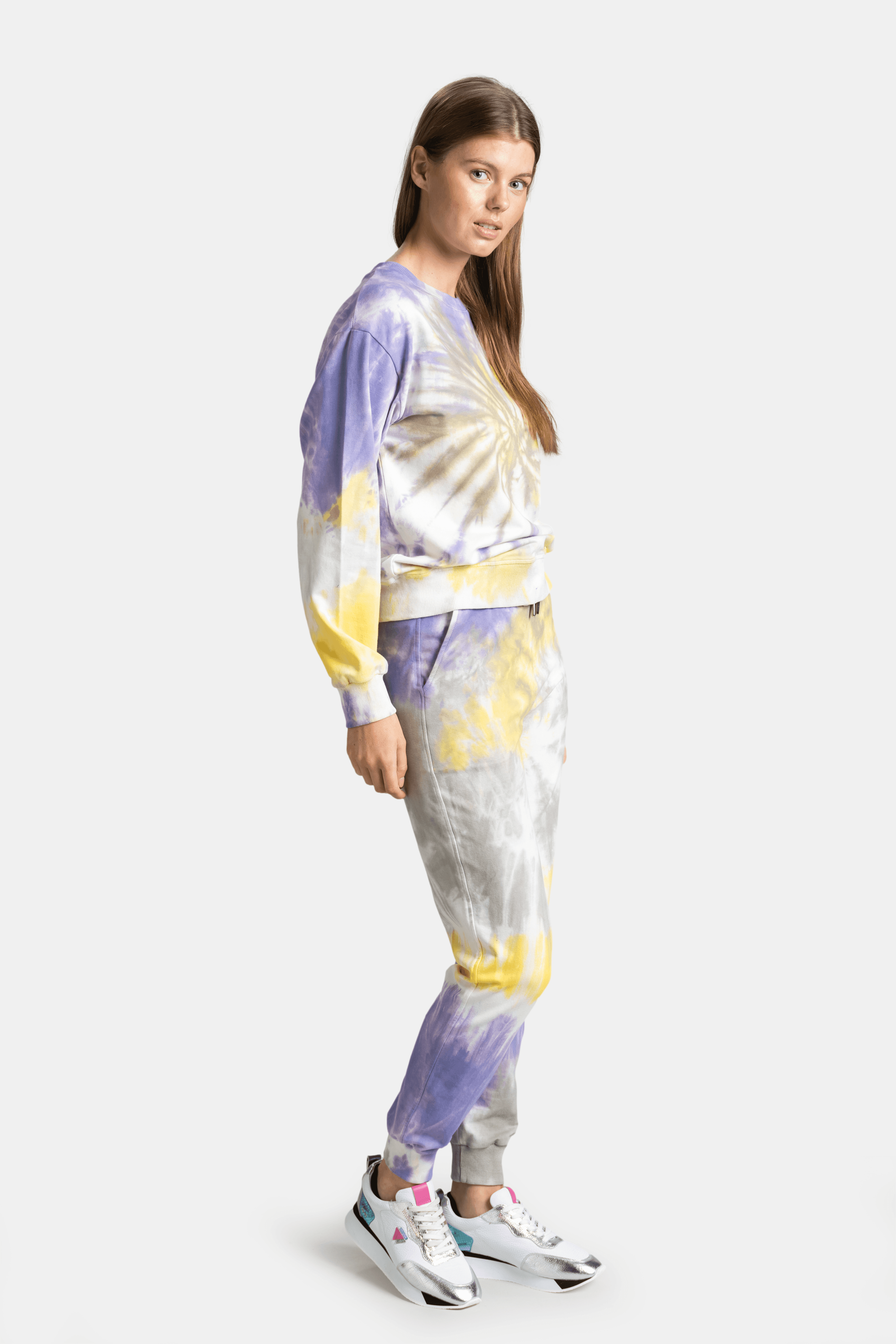 Side profile of vibrant tie-dye sweatshirt and joggers, featuring a blend of yellow, purple, and white, ideal for cozy and fashionable streetwear.