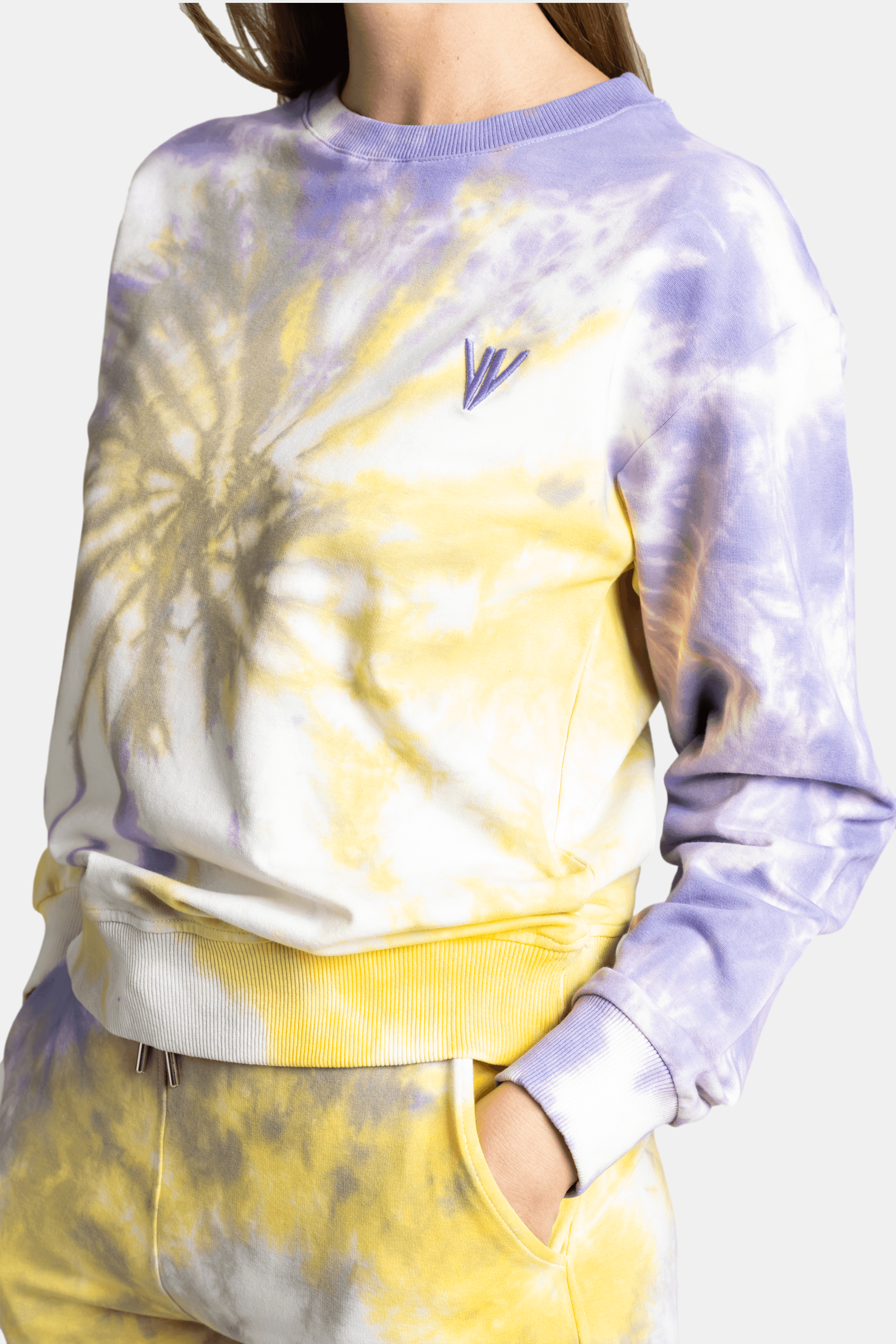 Close-up of tie-dye sweatshirt with yellow, purple, and white colors, offering a trendy and casual style for modern loungewear fashion.