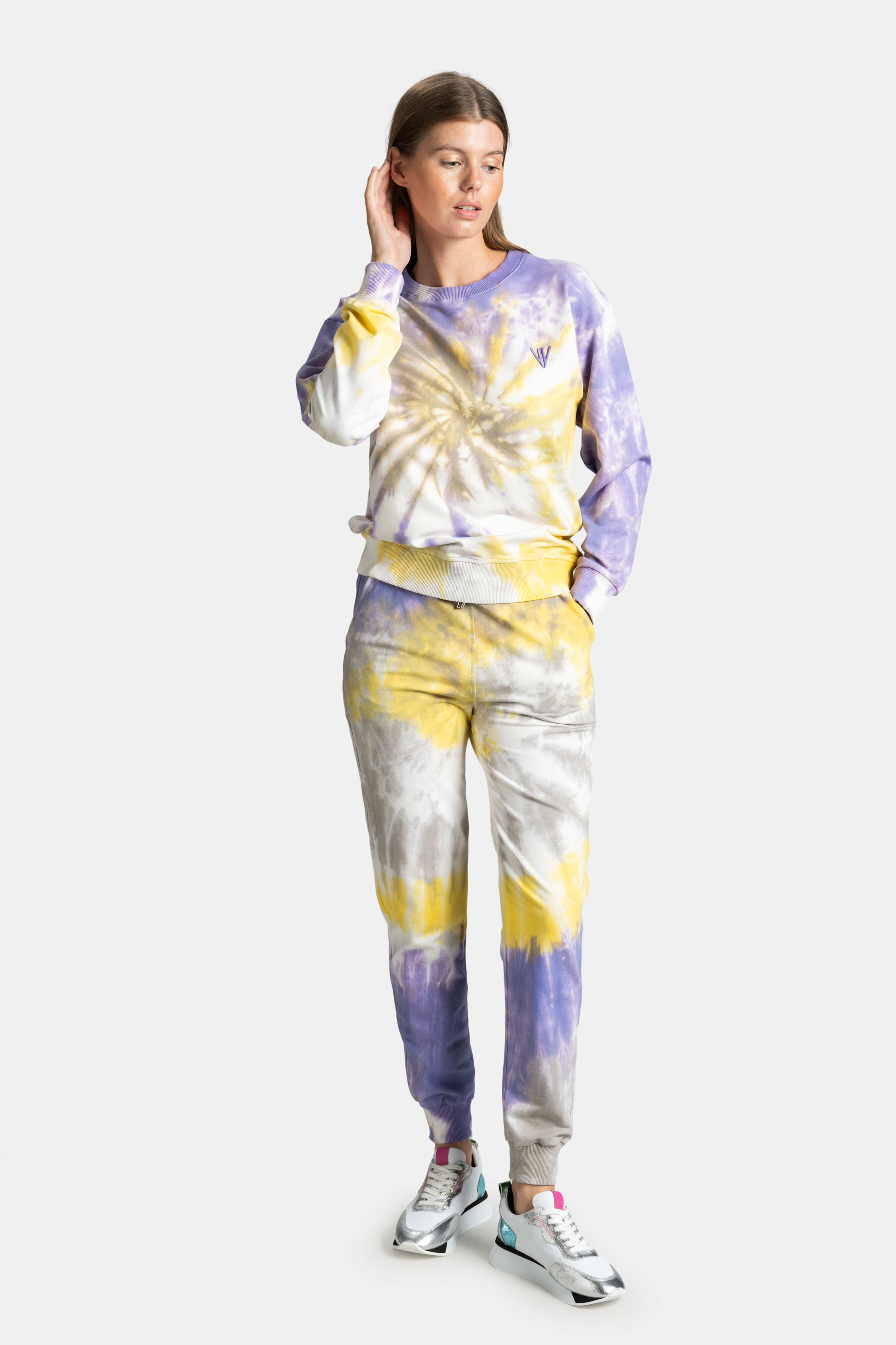 Model wearing NOWIHT tie-dye tracksuit in yellow, purple, and gray colors, showcasing relaxed and colorful street style.