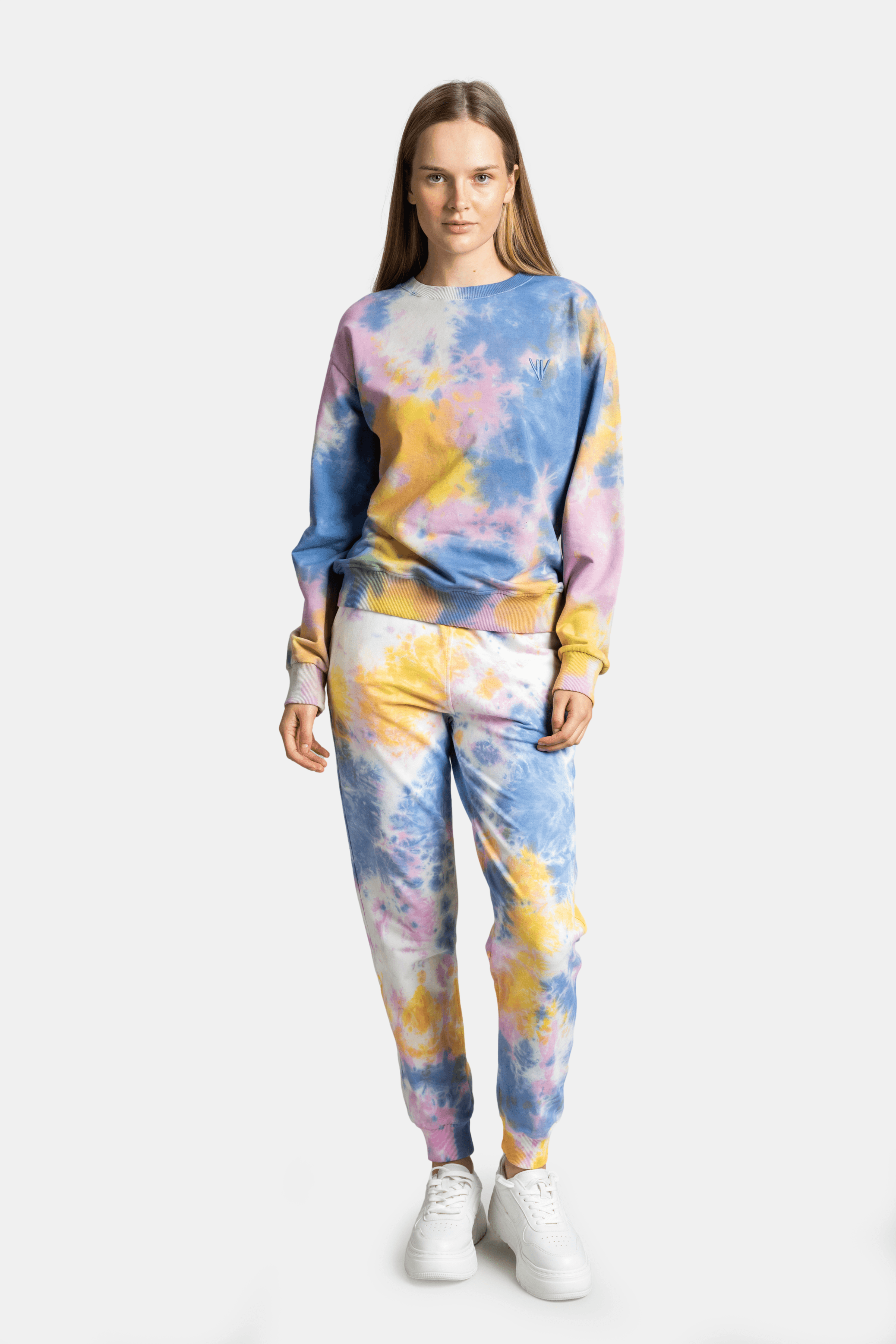 Model in front view wearing a tie-dye tracksuit set with pastel shades of pink, blue, and yellow.