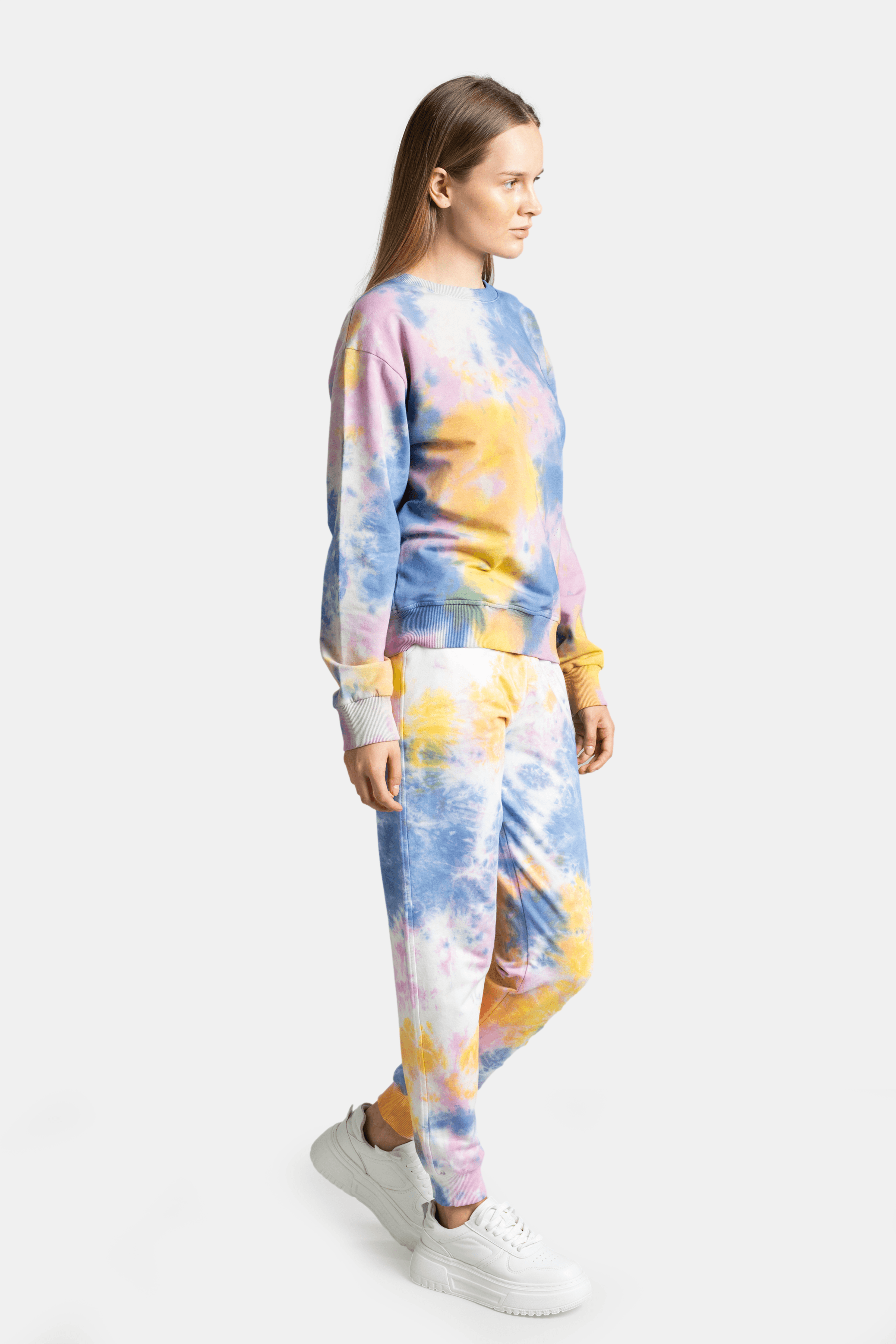 Model in side view wearing the tie-dye tracksuit set with a blend of pastel colors.