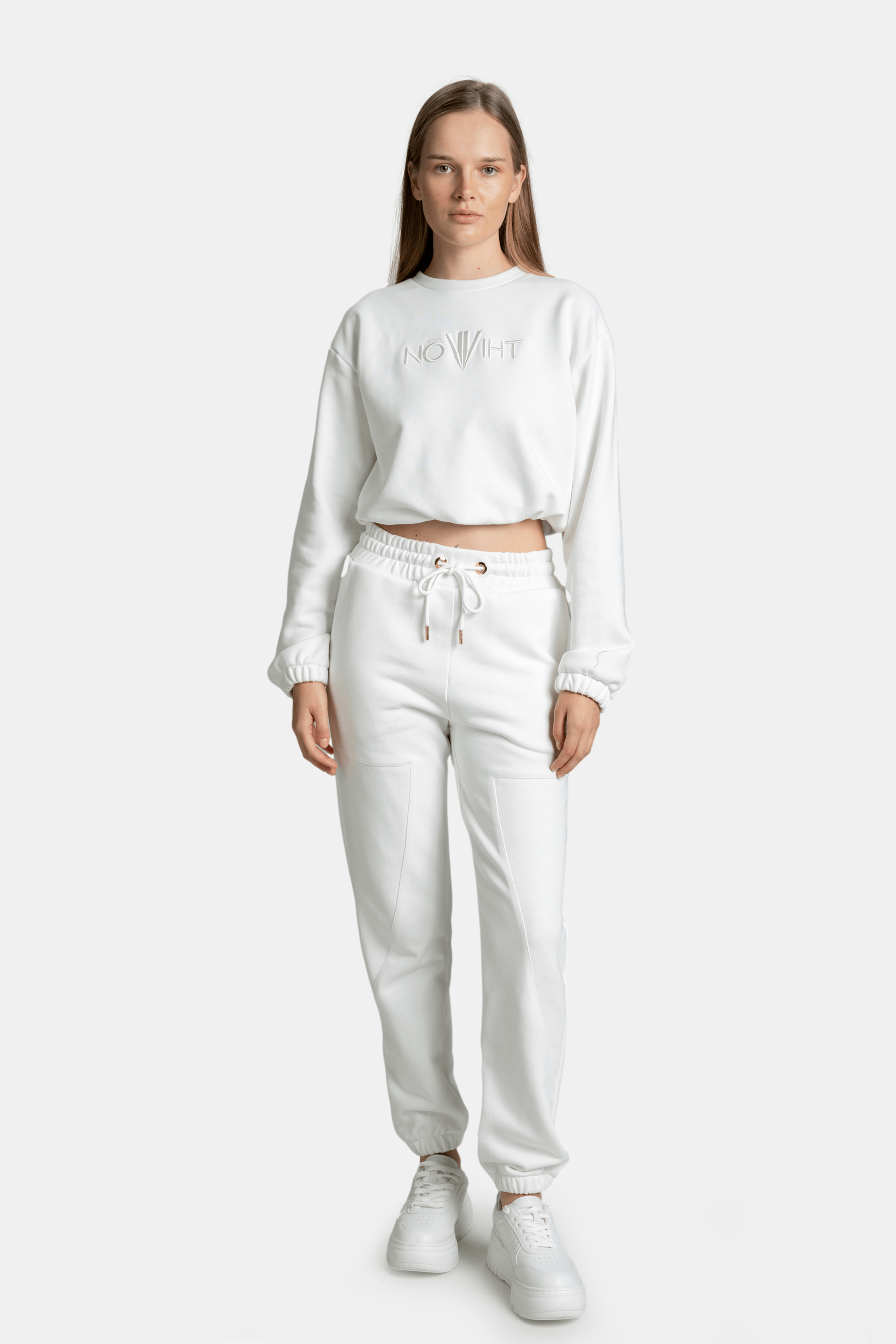 Front view of the model wearing a white Nowiht tracksuit set, showing the relaxed fit and logo on the sweatshirt.