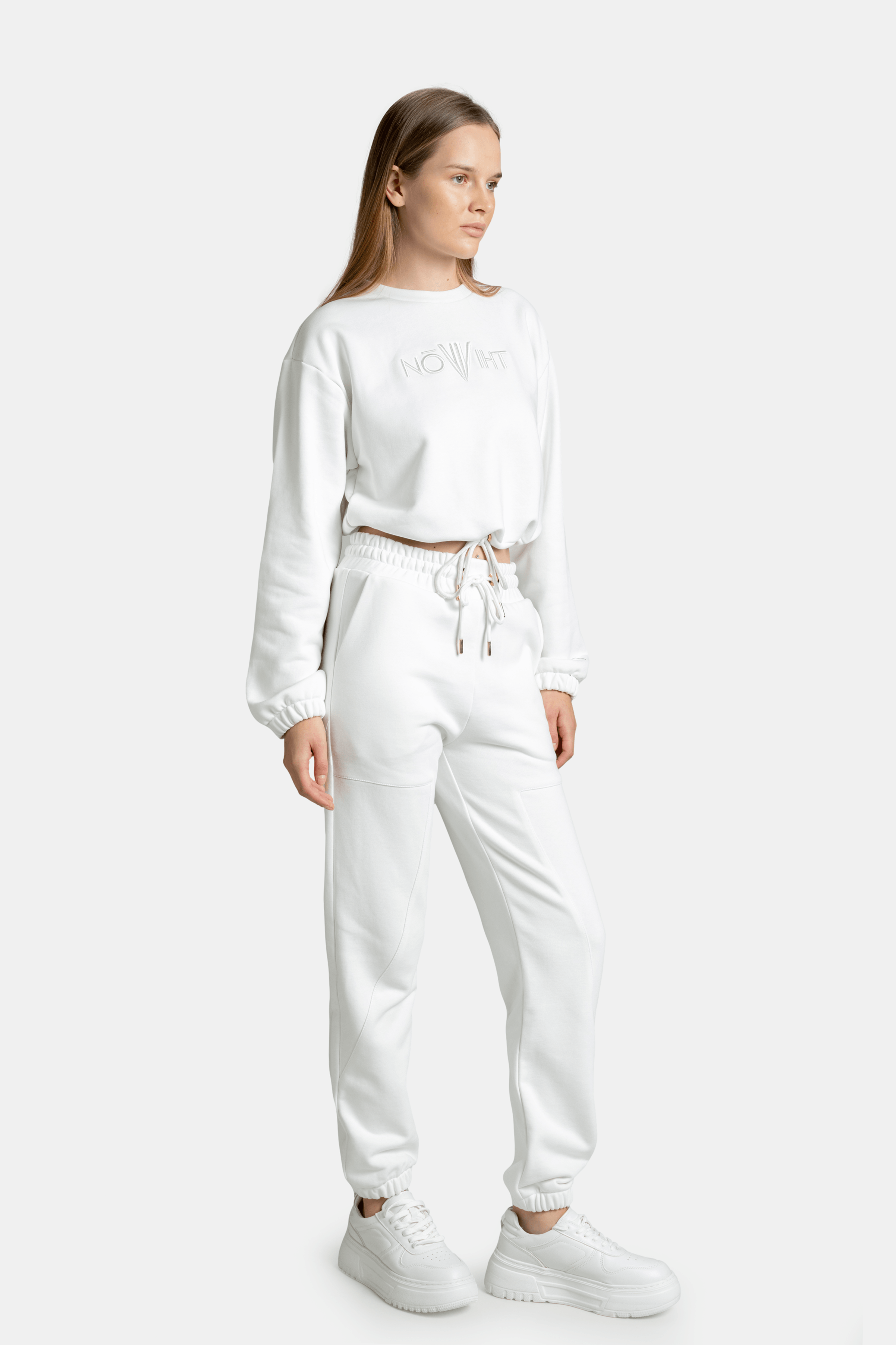 Side view of the model in the white Nowiht tracksuit set, featuring the stylish and minimal design.