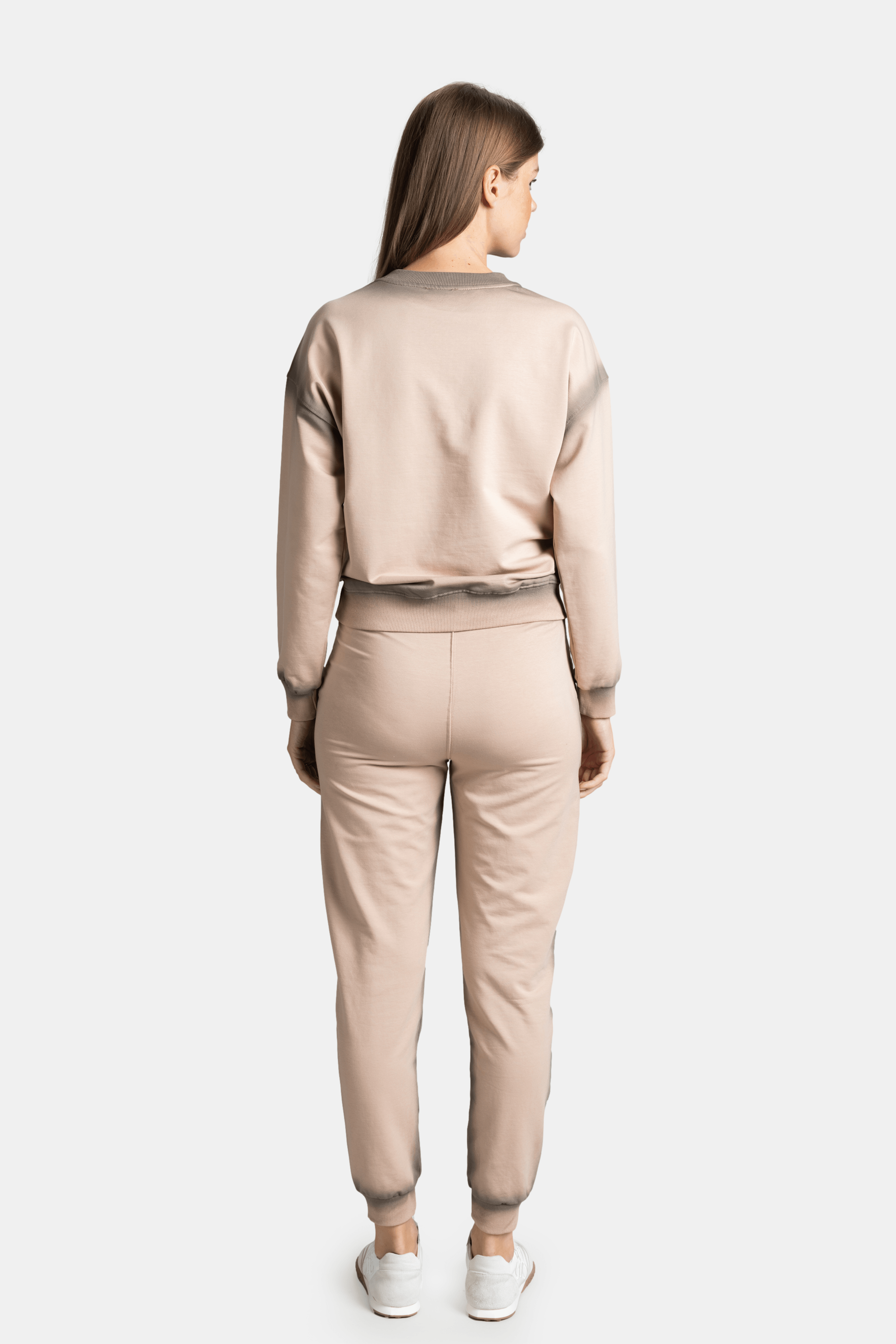 Full back view of model in beige tracksuit, showing the fit and detail of the back.