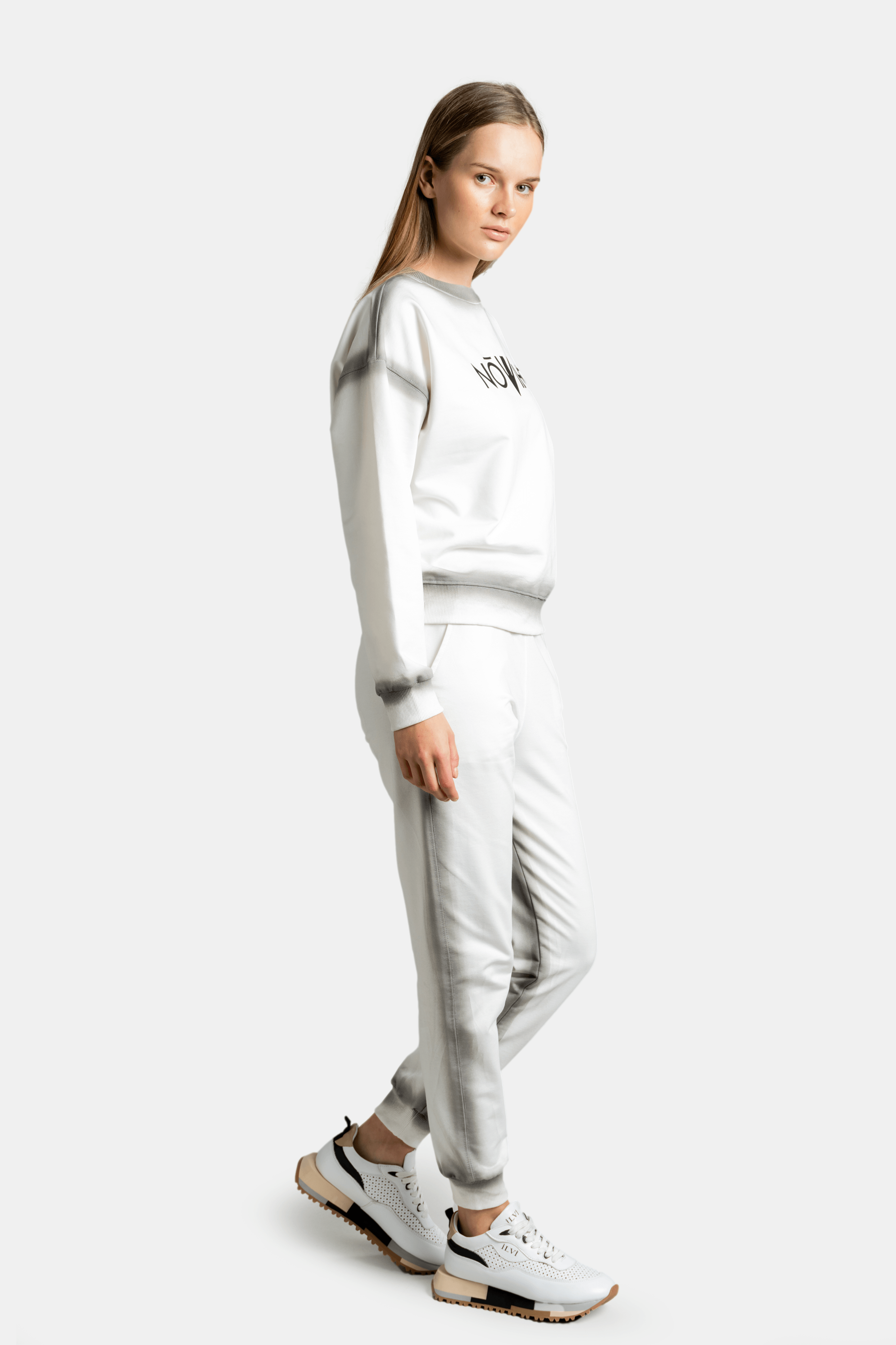 Side view of the model in a light grey sweatsuit, highlighting the outfit’s casual fit and comfortable design.