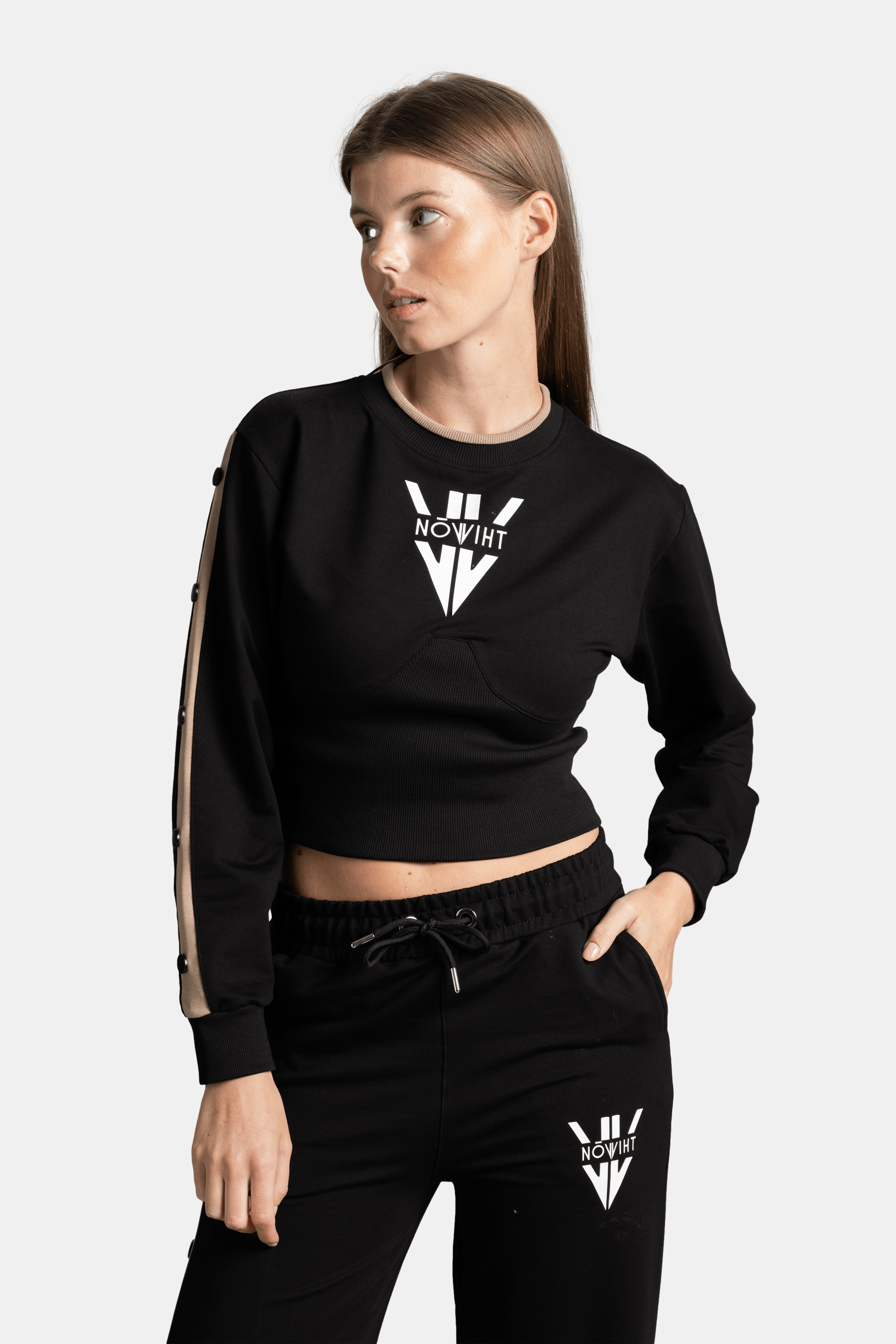 Another close-up front view of a woman in a black cropped sweatshirt with a white logo, focusing on the clean, modern style.