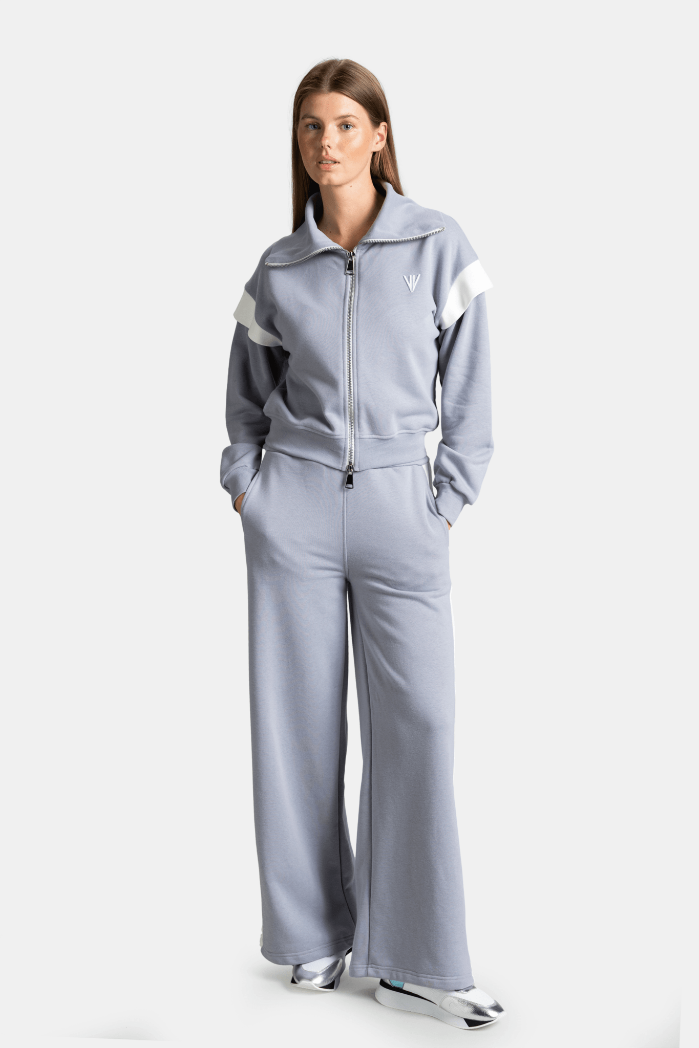 Front view of model wearing Ciara zip sweatshirt tracksuit set in navy with white stripe accents